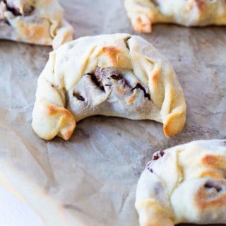 Five empandas on a cookie sheet with parchment paper