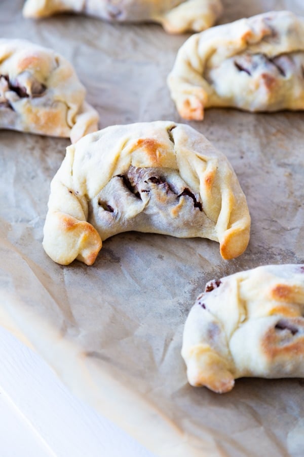 Five empandas on a cookie sheet with parchment paper