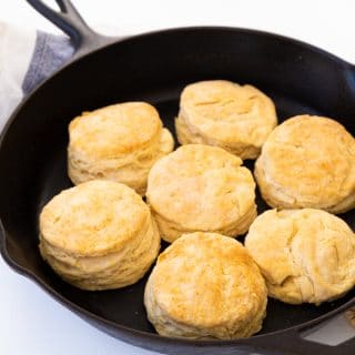 Golden brown baked biscuits in a black cast-iron skillet