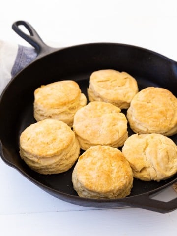 Golden brown baked biscuits in a black cast-iron skillet