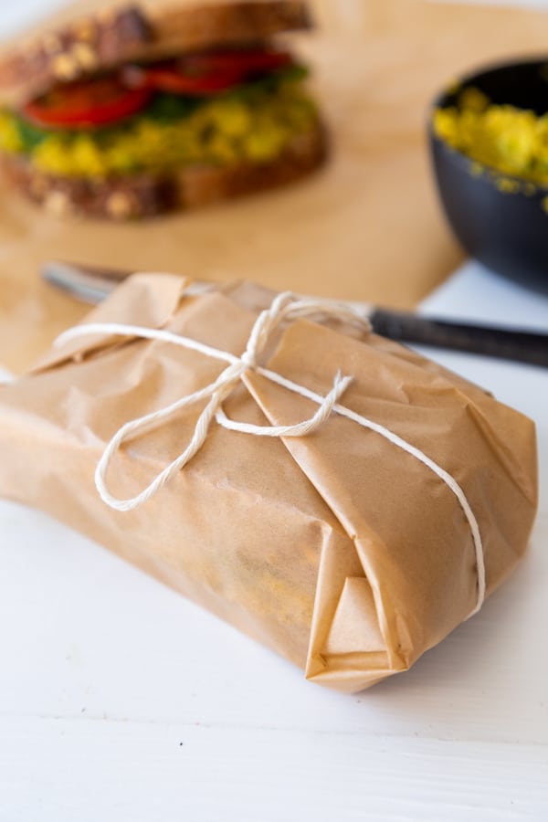 a sandwich wrapped in parchment paper and tied in a bow with cooking twine