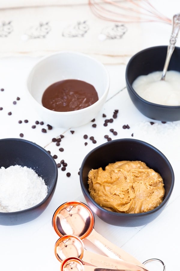 Black and white bowls with peanut butter, powdered sugar, condensed milk, and vanilla