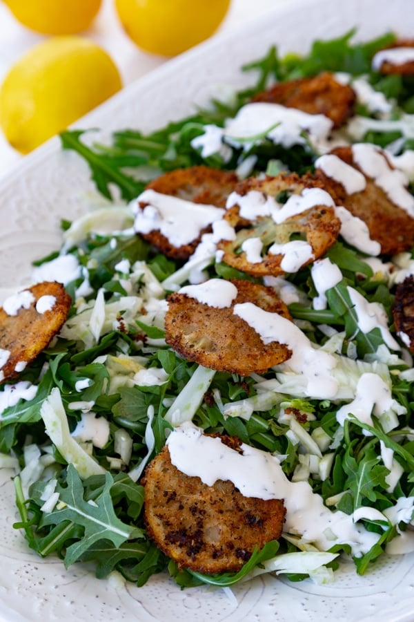 Delicious and delicate fried lemons in an arugula and fennel salad with a creamy lemon dressing! Totally vegan! #vegan #salad #friedlemons