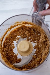vegan cheesecake crust being made in a food processor