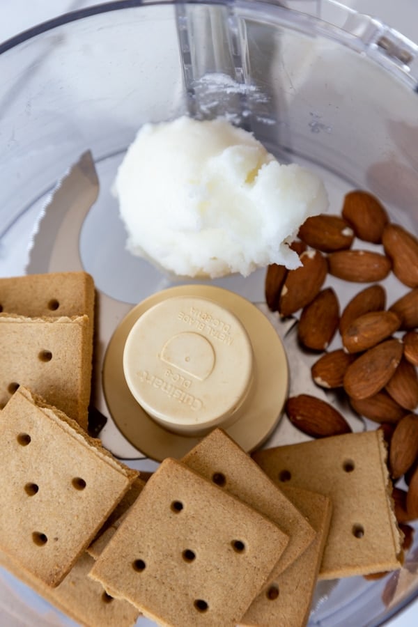 Graham crackers, almonds, and coconut oil in a food processor.