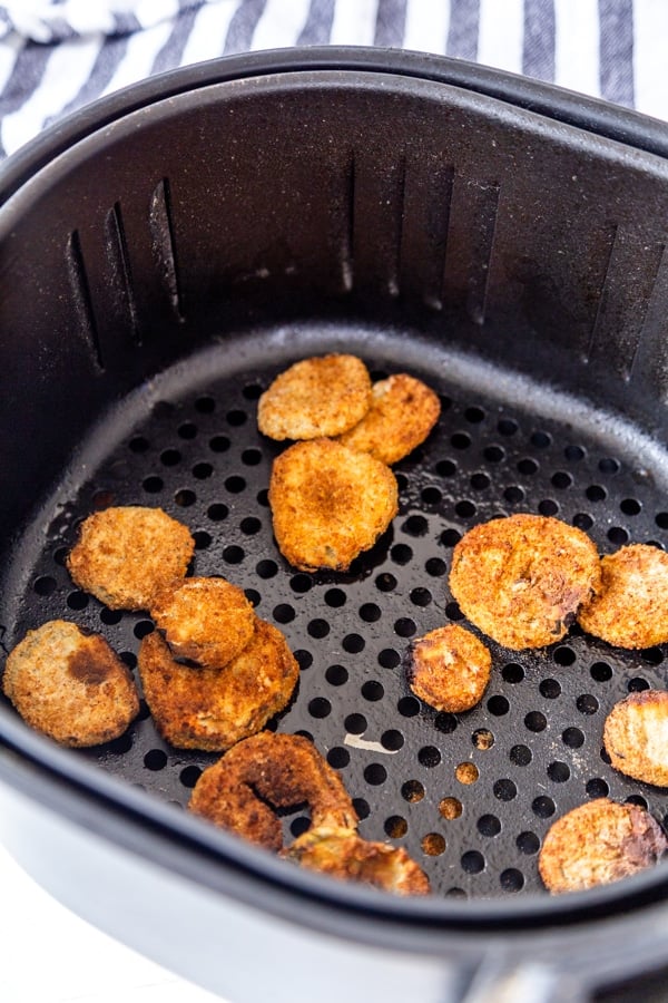 Fried pickles in an air fryer basket.