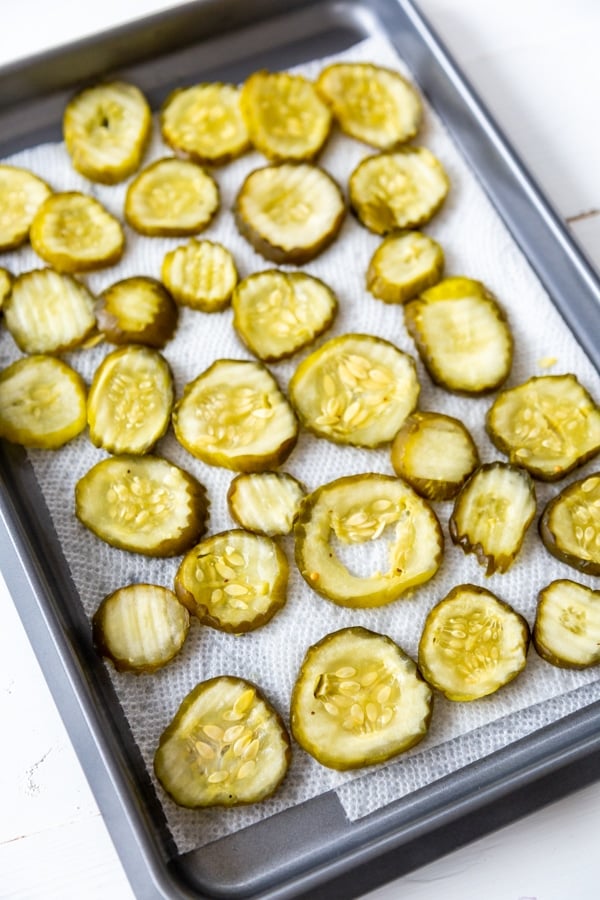 A pan of pickles drying on paper towels.