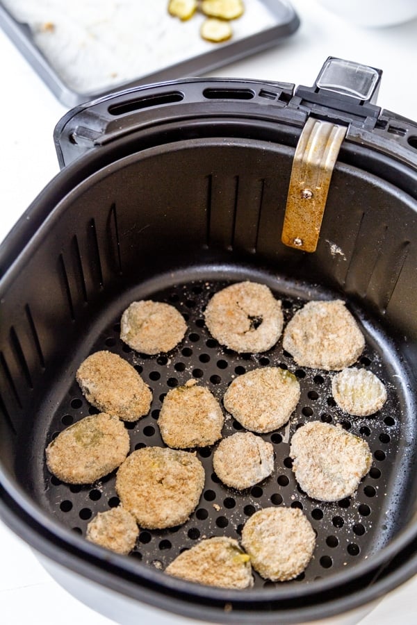 Battered pickle chips in an air fryer to make fried pickles.