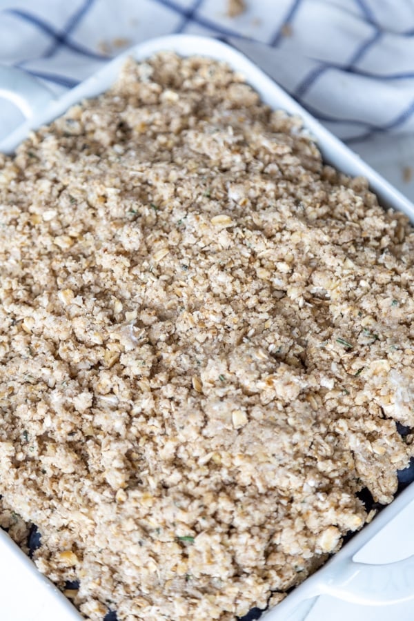 A square white pan of blueberries with a oat and flour topping.