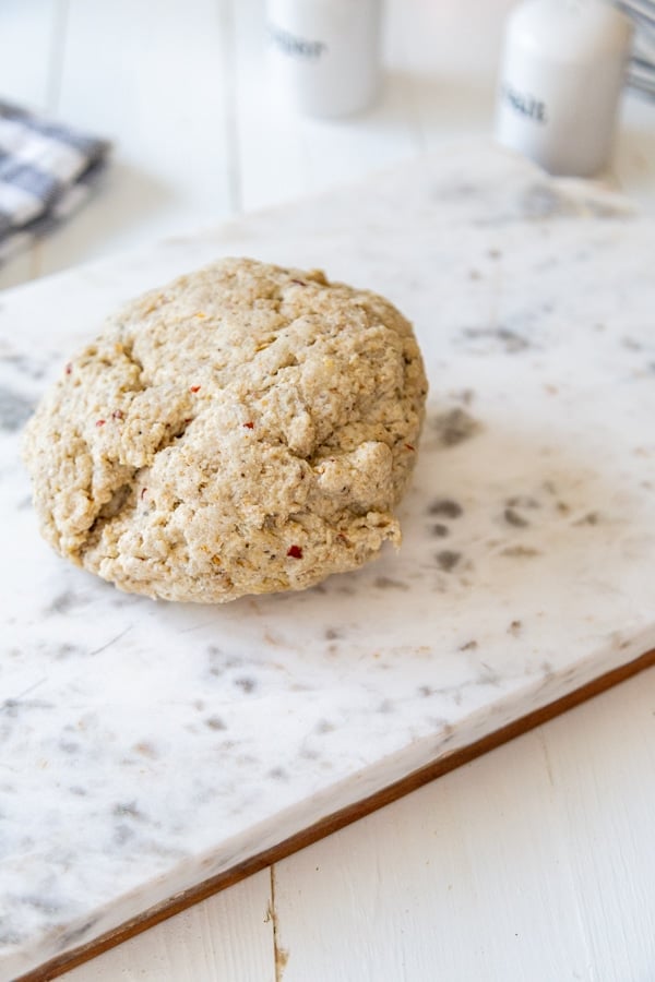 A ball of dough on a marble board.