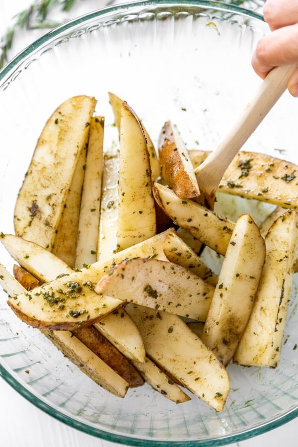 A bowl of sliced potatoes with a spoon.