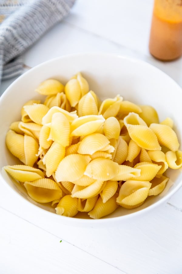 A white bowl with macaroni shells.