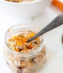 A mason jar with overnight oats topped with shredded carrots.