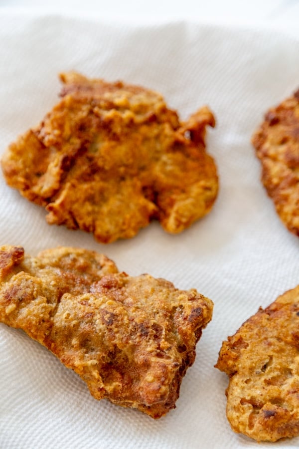 Four pieces of fried chicken on a paper towel.