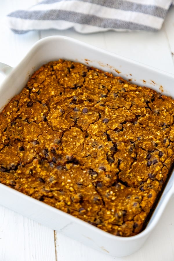 Pumpkin chocolate chip blondies in a square white baking dish. 