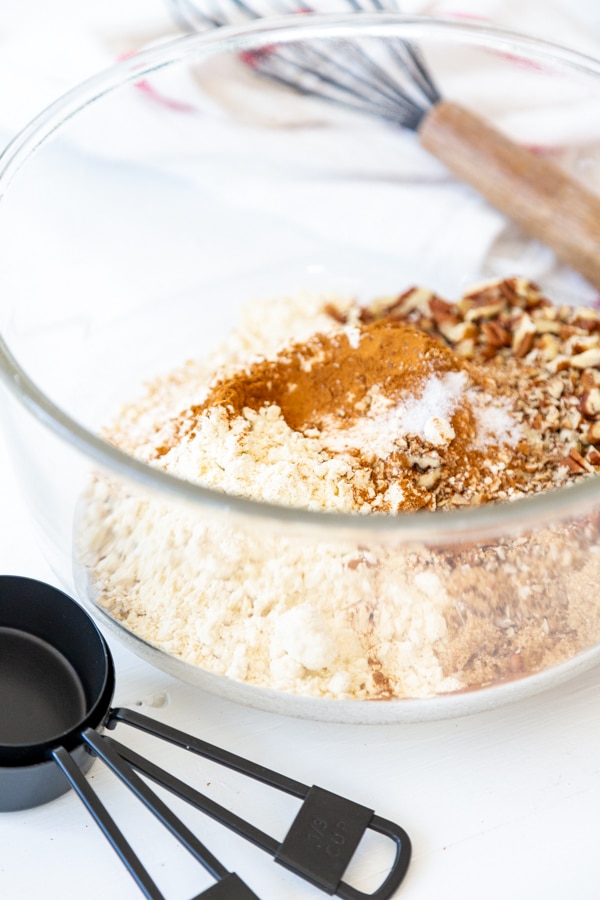 A glass bowl with oats, flour, and spices
