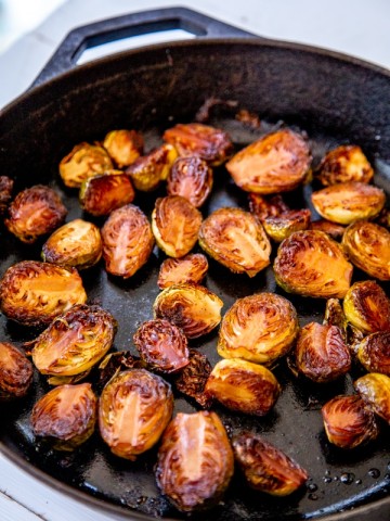 An iron skillet with roasted Brussels sprouts.