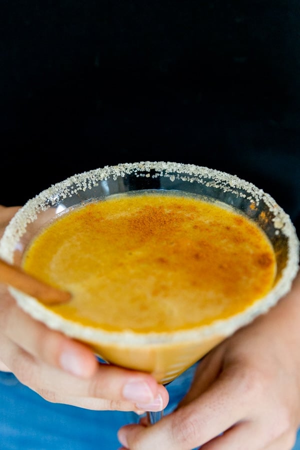 Hands holding a pumpkin spice martini.