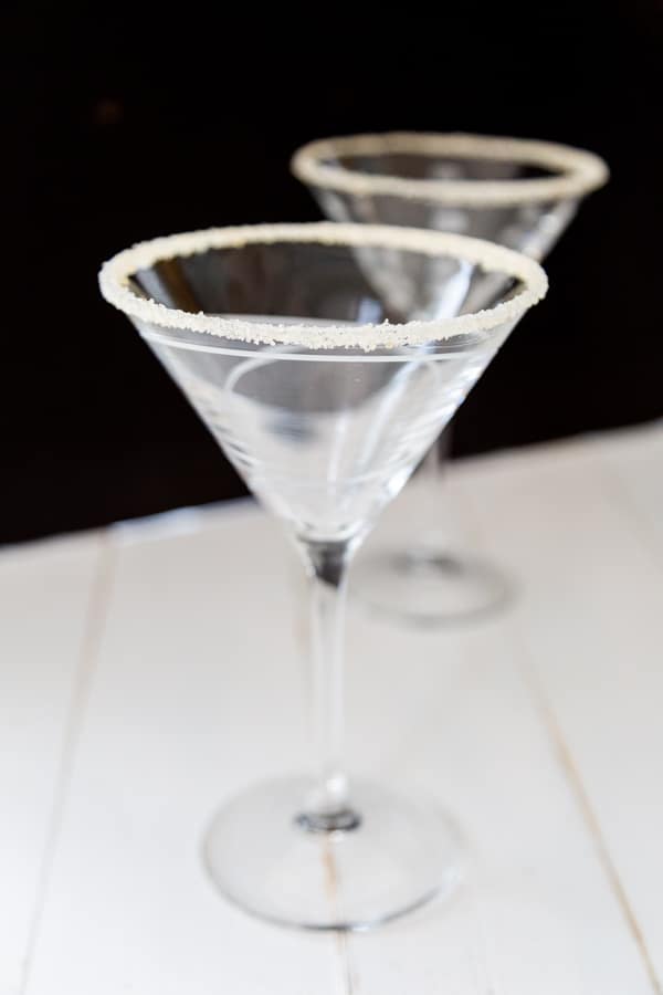 Two empty martini glasses with sugar on the rims.