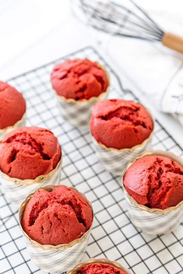 Red velvet cupcakes cooling on a wire cooling rack.