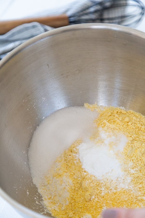 Cornmeal and flour in a silver mixing bowl.