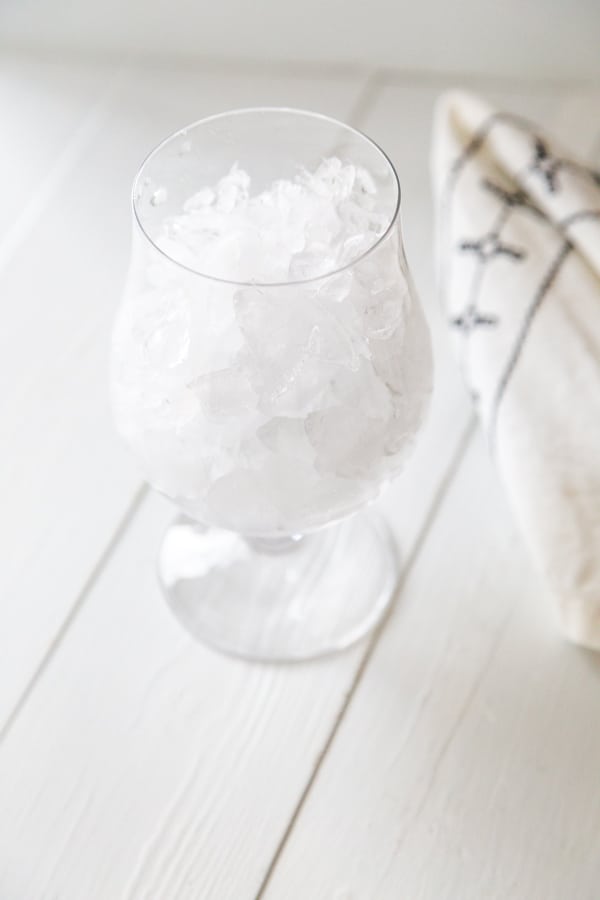 A glass filled with ice on a white table.