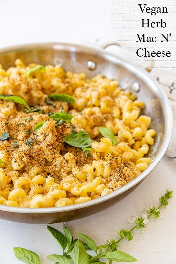 A round copper pan with baked mac'n' cheese and herbs. 