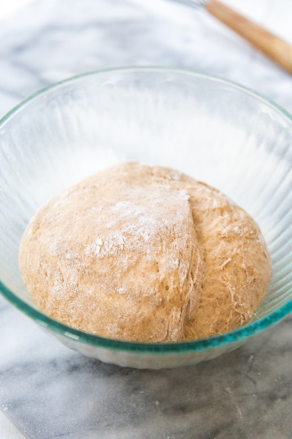 A glass bowl with rising dough.