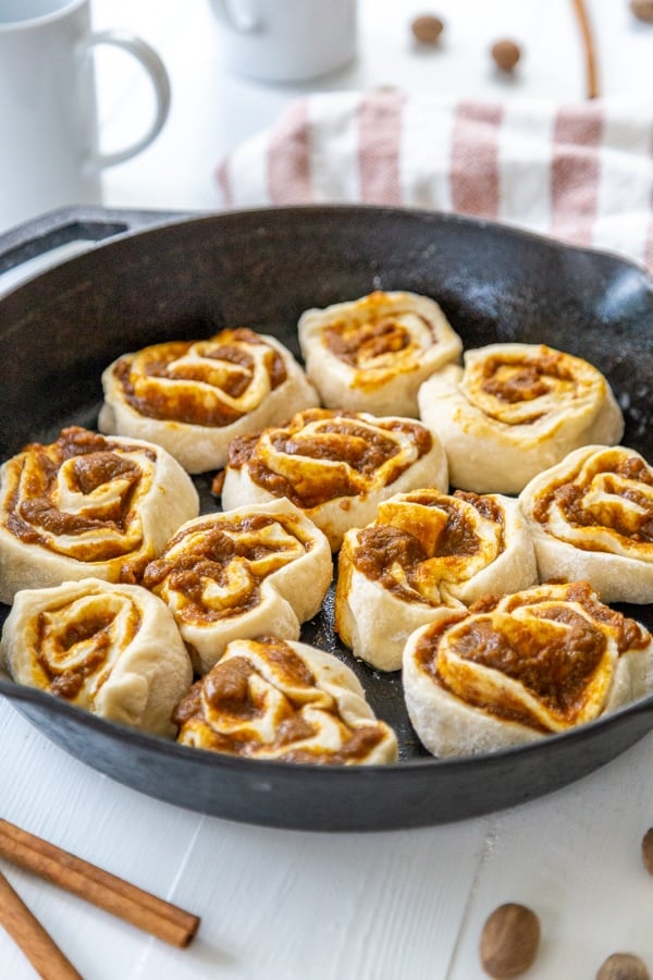 Pumpkin cinnamon rolls in an iron skillet.