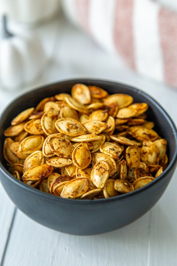 A black bowl with spicy roasted pumpkin seeds. 