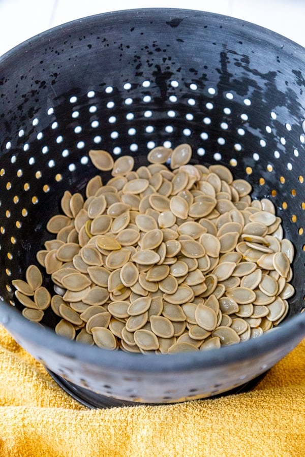 A colander with pumpkin seeds .