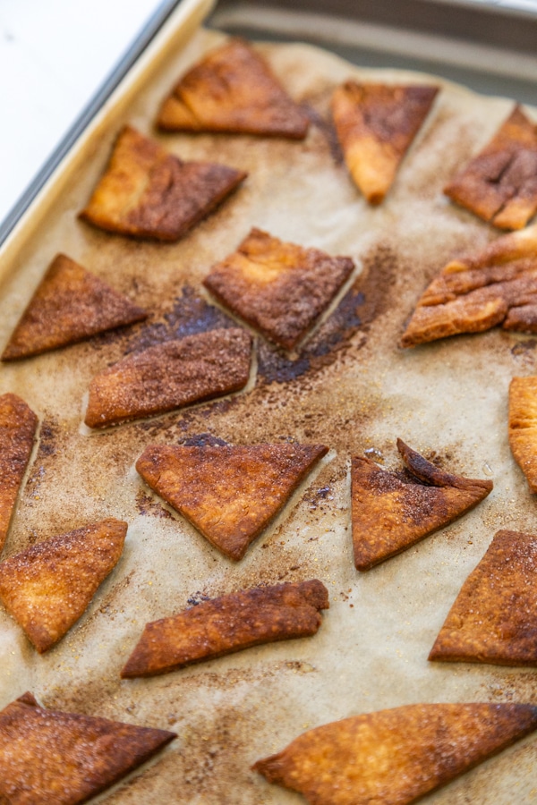 Baked pie crust chips on a parchment lined baking sheet. 