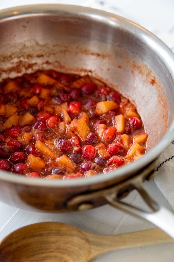 A copper pot with cranberry apple compote.