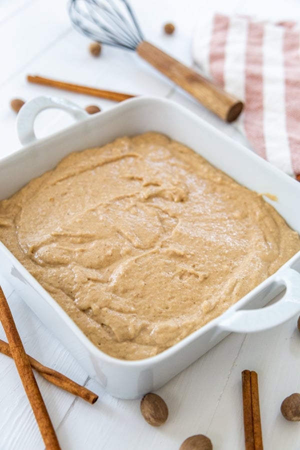 Spice cake batter in a square white cake pan before baking.