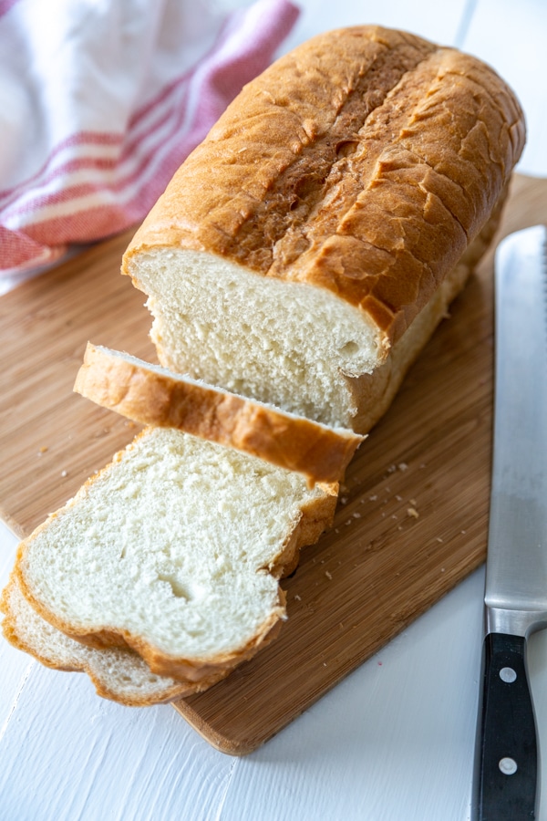 A loaf of white bread with 2 slices cut off the end. 