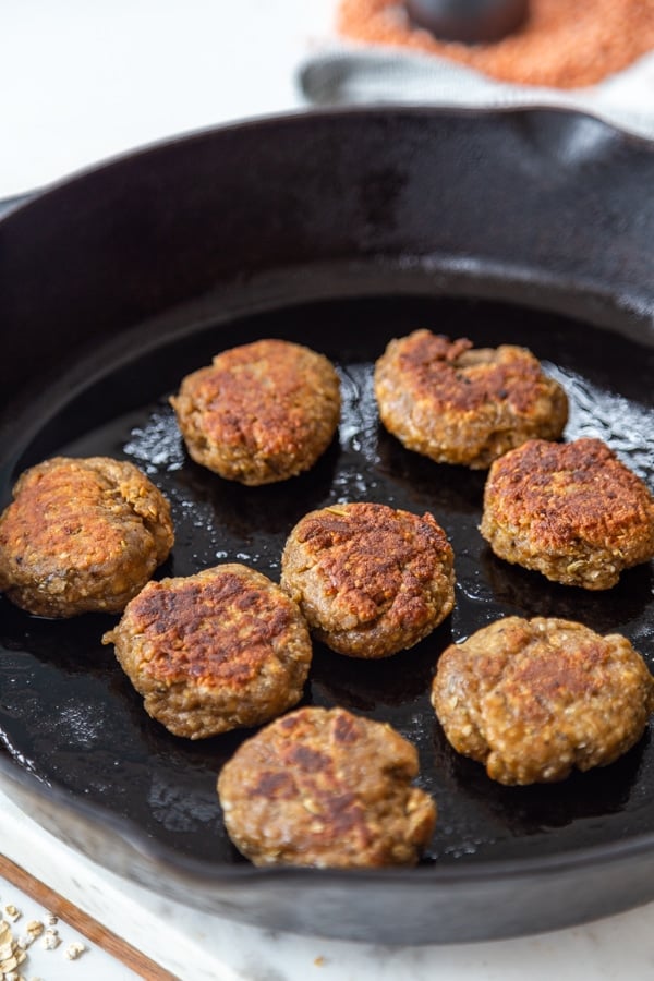 An iron skillet with breakfast sausage patties.