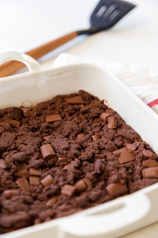 A white square dish with chocolate chunk brownies. 