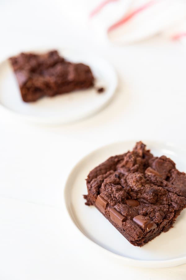 Two white plates with brownies. 