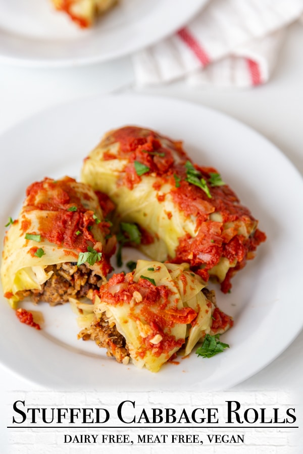 A Pinterest pin for stuffed vegan cabbage rolls with a picture of the rolls on a white plate. 