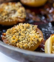 A copper pan with roasted onions and fennel breadcrumbs.