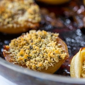 A copper pan with roasted onions and fennel breadcrumbs.