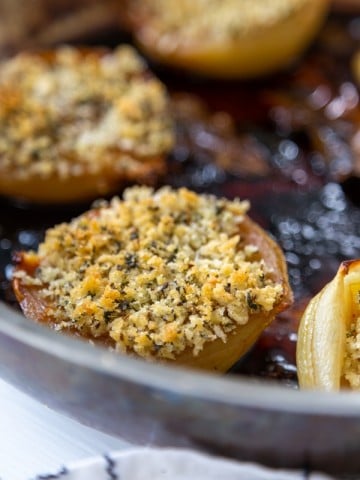 A copper pan with roasted onions and fennel breadcrumbs.