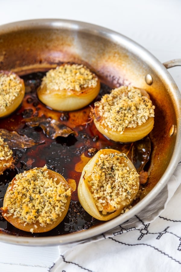 A round baking dish with roasted onions topped with a savory breadcrumb topping.