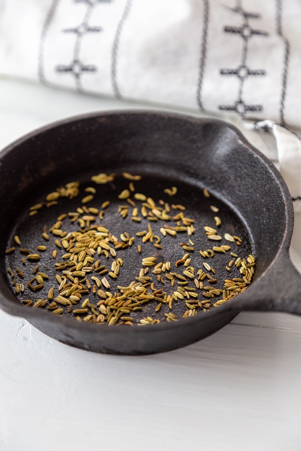 An iron skillet with toasted fennel seeds.