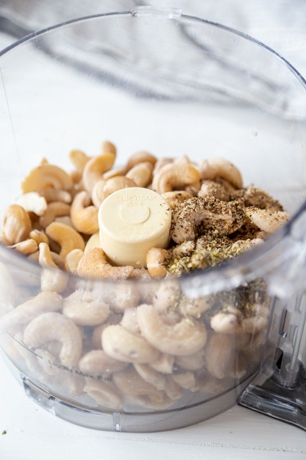 A food processor with cashews and spices.