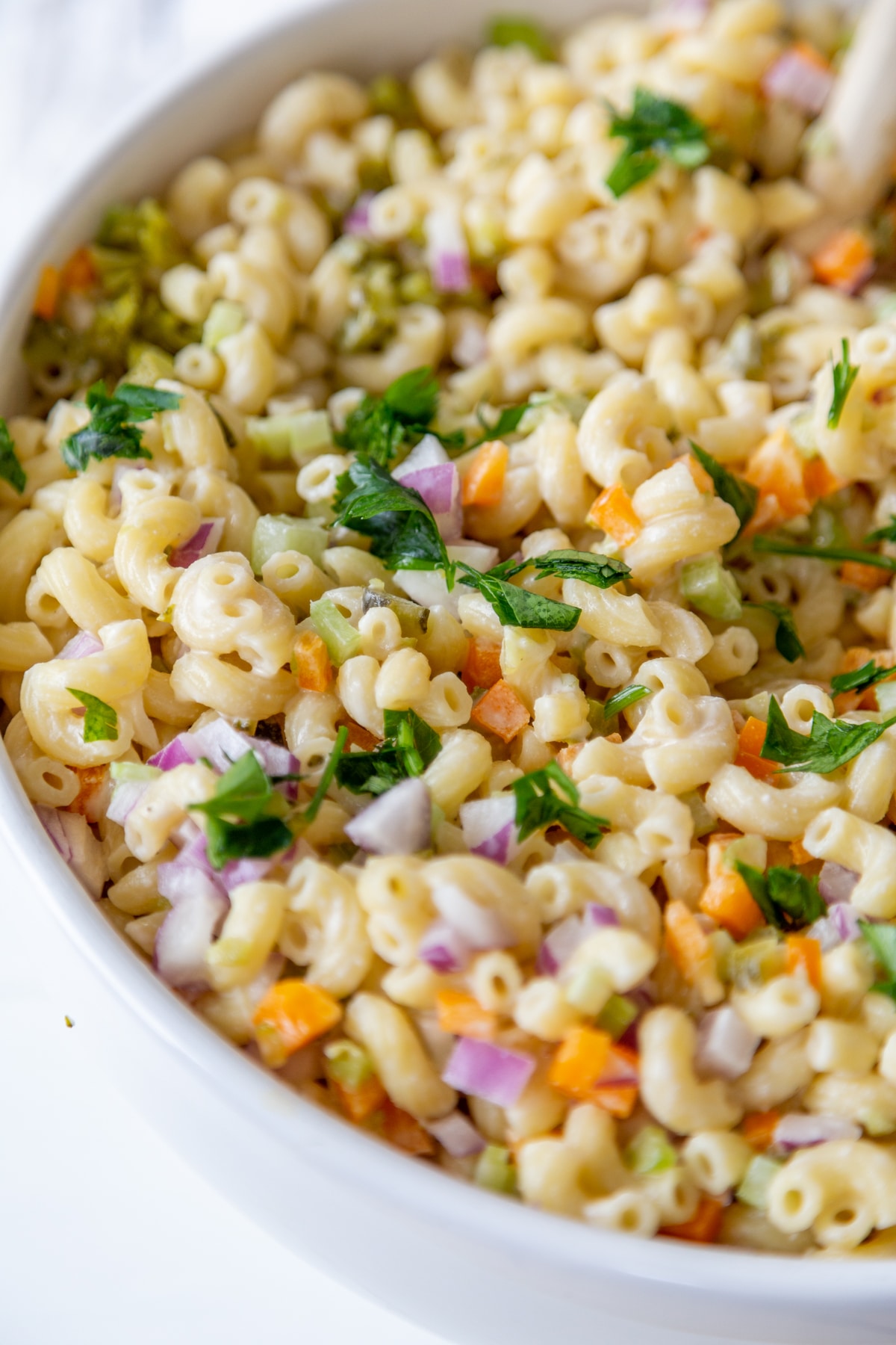 A white bowl filled with macaroni salad.