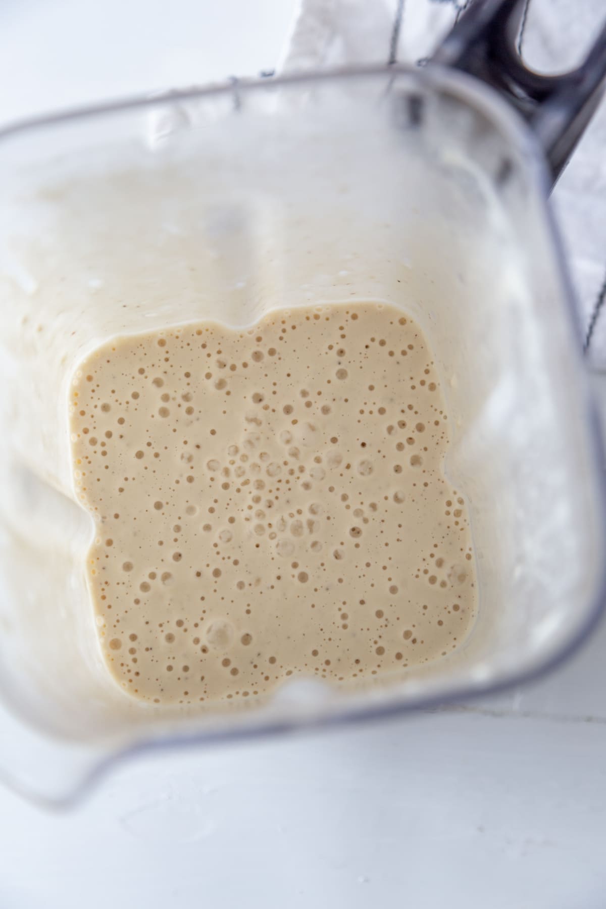 A blender with a creamy salad dressing.