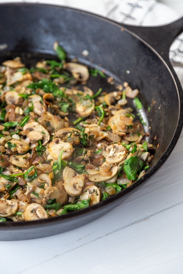 An iron skillet with mushrooms and onions. 