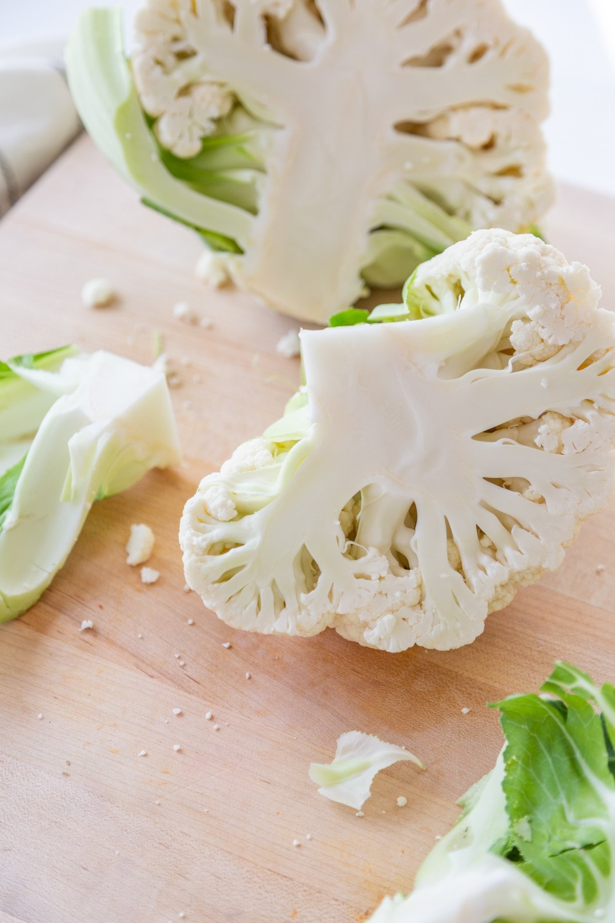 A head of cauliflower cut in half with the core removed from one half. 