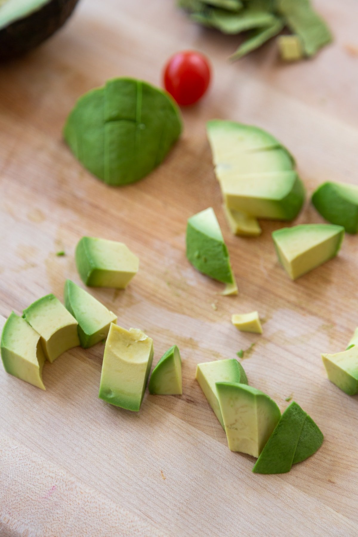 Cubed avocado on a wooden cutting board.